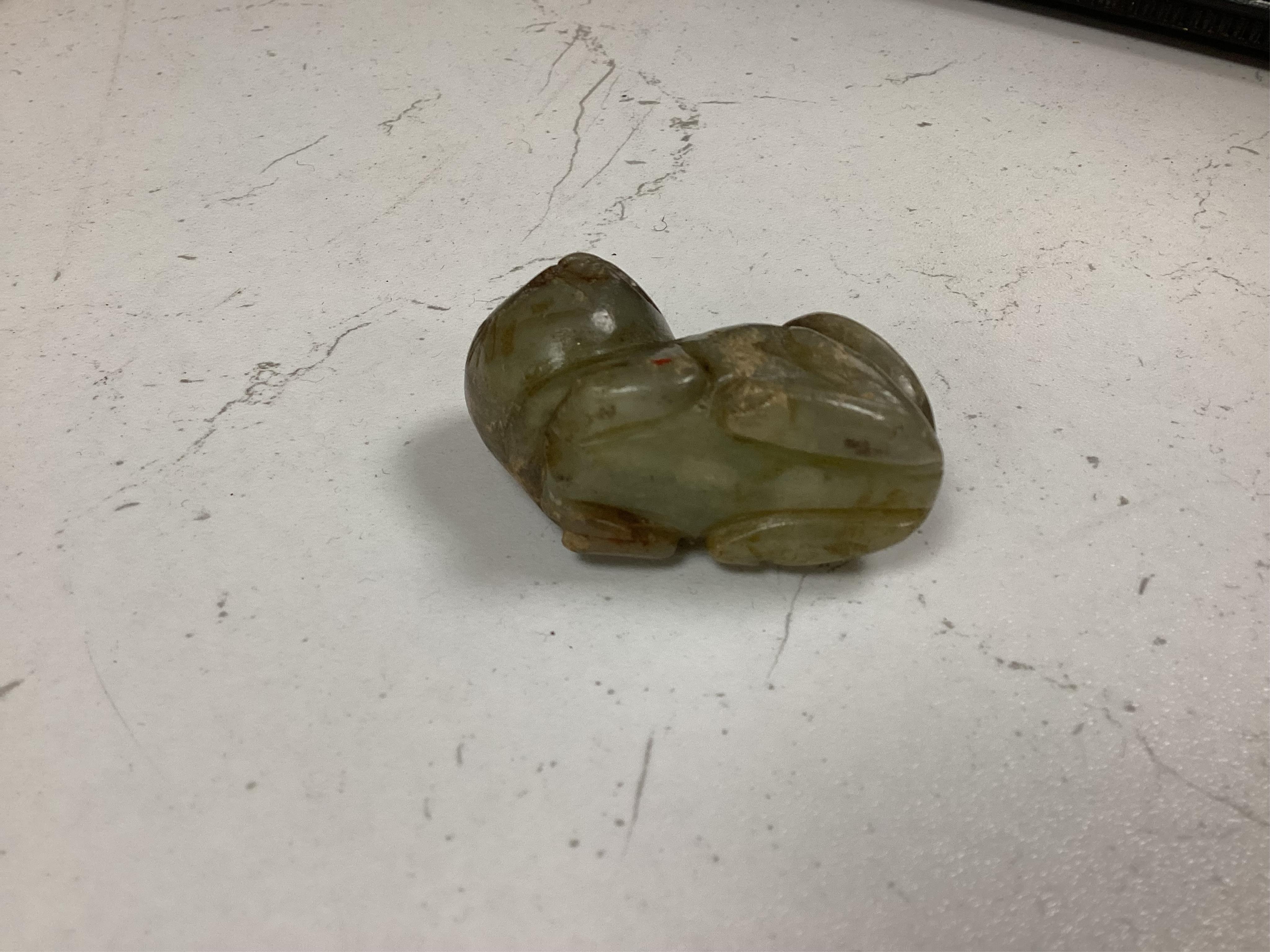 A Chinese red lacquered bead necklace and a bowenite jade figure of a cat